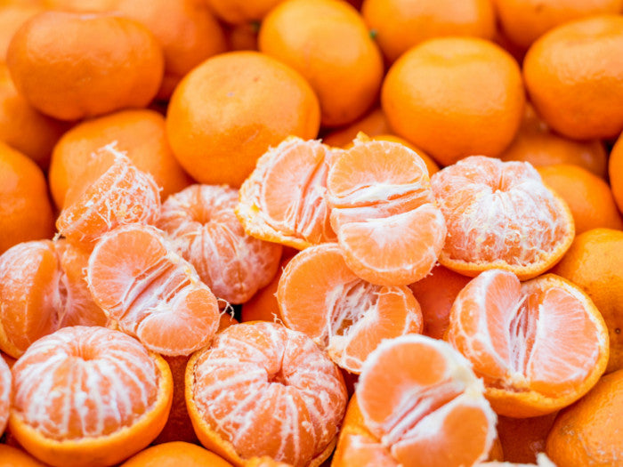 Lots of mandarin oranges, many have been peeled to show the edible sections.